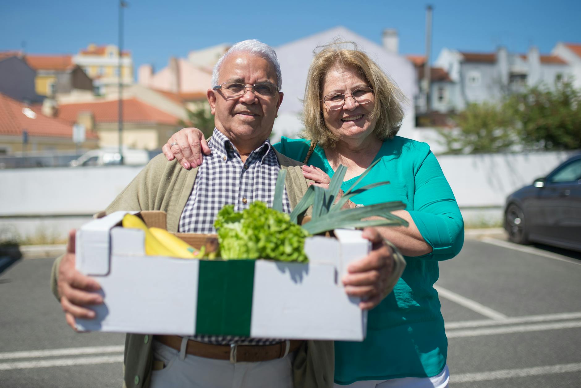 Starsza para z pudełkiem świeżych warzyw na ulicy w Portugalii