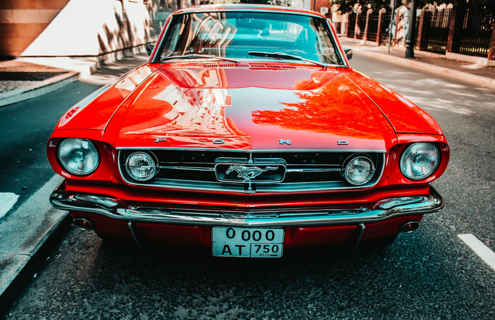 Czerwony klasyczny Ford Mustang widziany od przodu na miejskiej ulicy