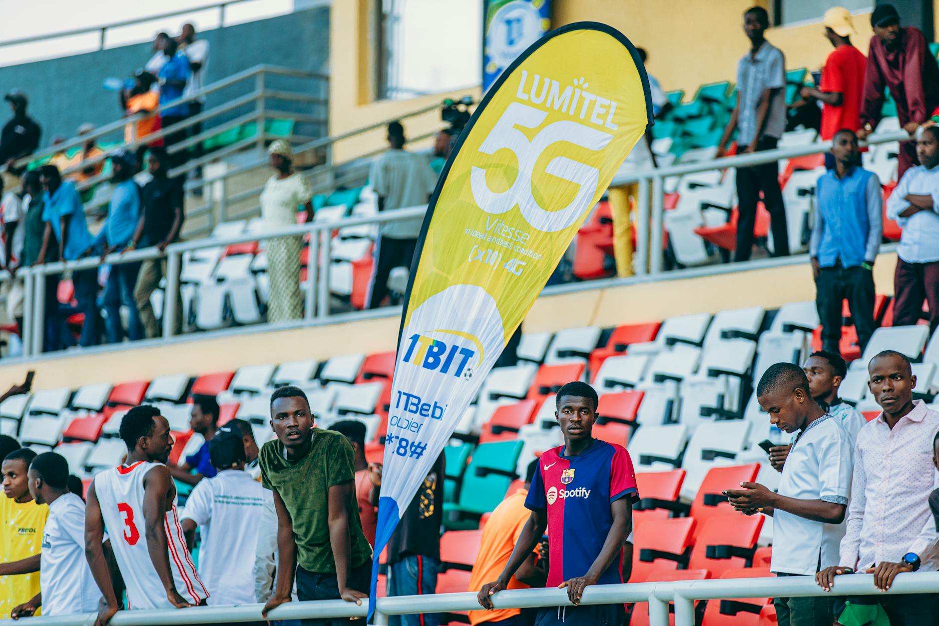 Tłum kibiców na stadionie obok baneru promującego sieć 5G